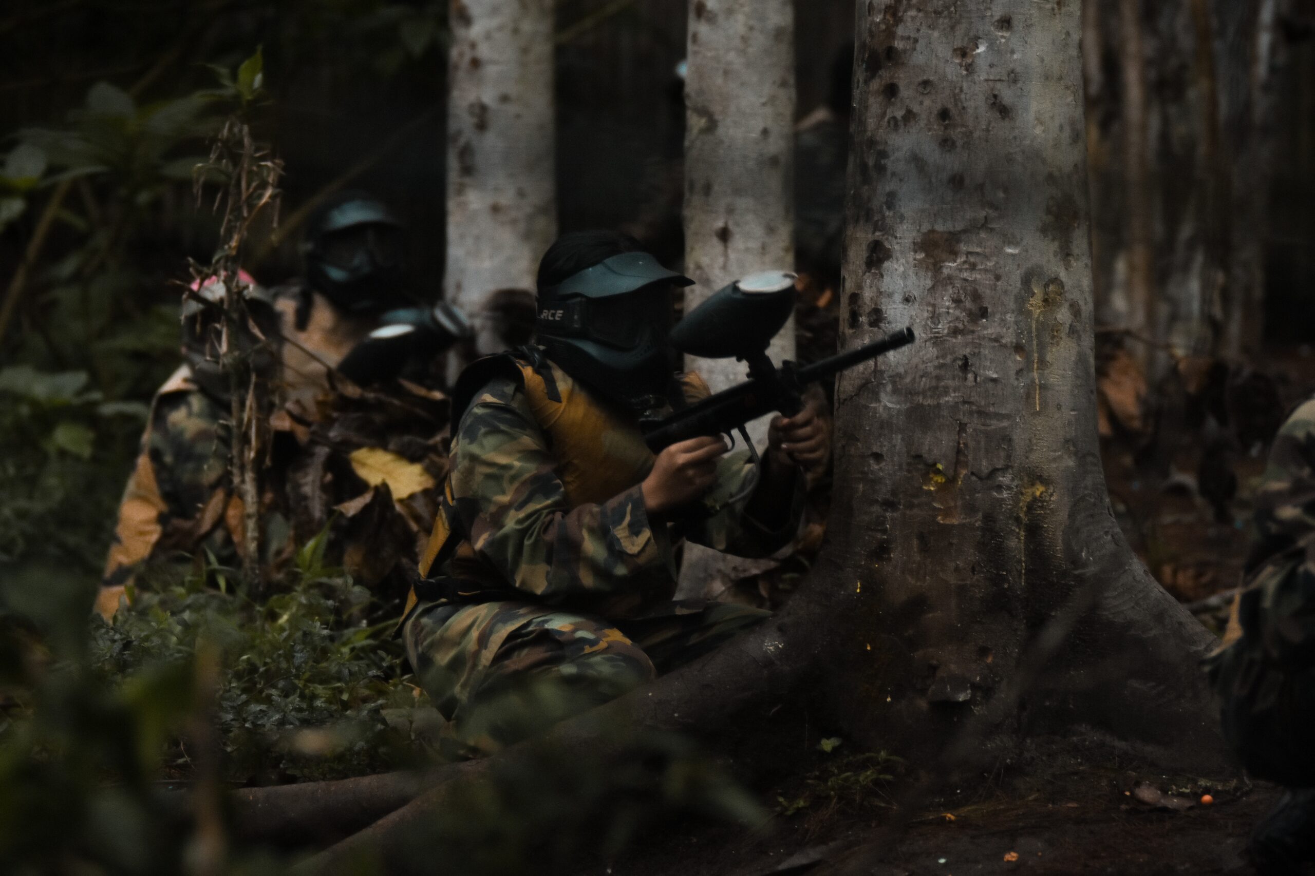 Group of people playing paintball in the woods