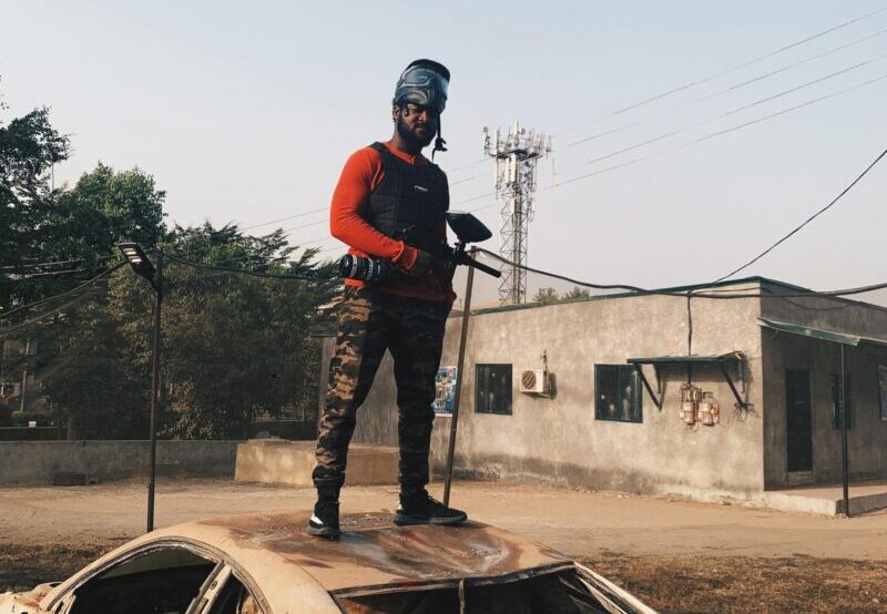 Paintball player standing on car